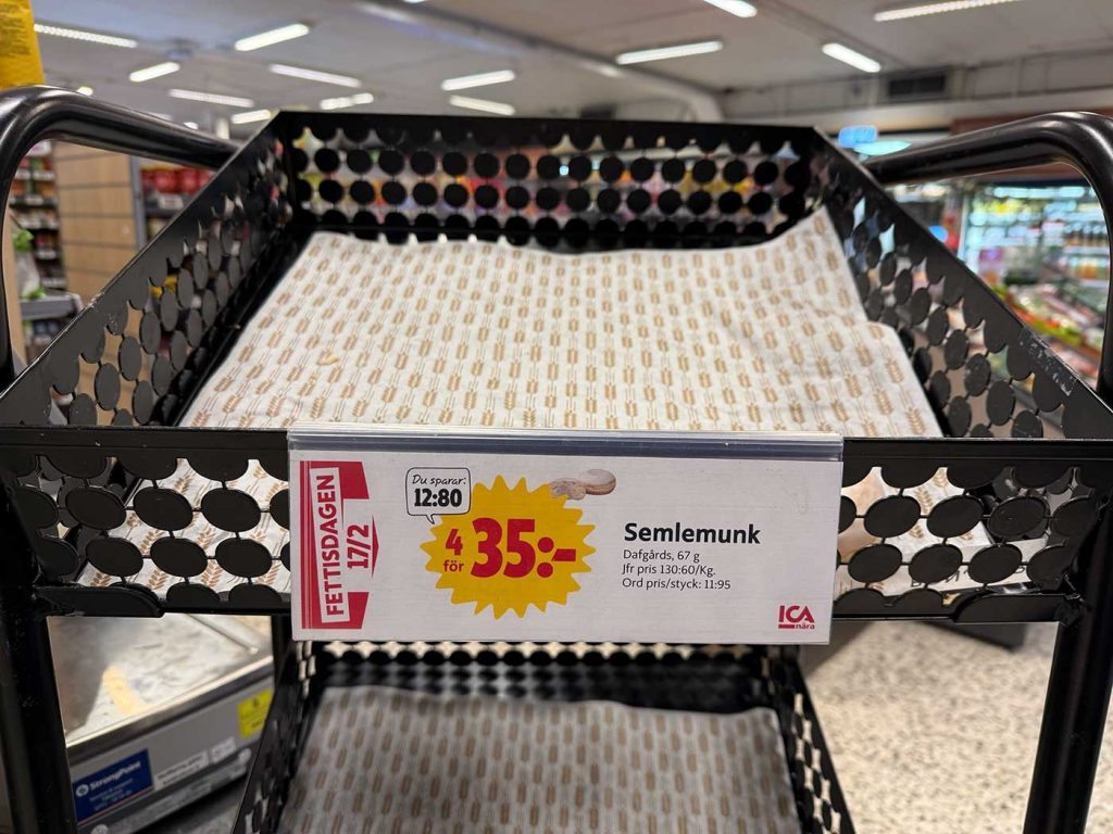 En tom korg i en butik med en skylt där det står att du kan köpa 4 semlemunkar för 35 kronor. 