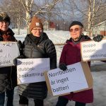 Tre välklädda damer håller upp skyltar med texterna ”Reglera elnätsmonopolet”, ”Stoppa dubbelbeskattningen” och ”Norrbotten är inget batteri”.