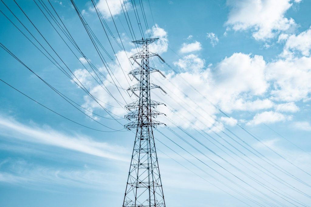 black electric tower under blue sky and white clouds during daytime